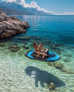 two women on a blue jet ski in clear water