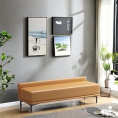 a living room with two pictures on the wall and a couch in front of it