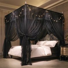 a black canopy bed with lights on it