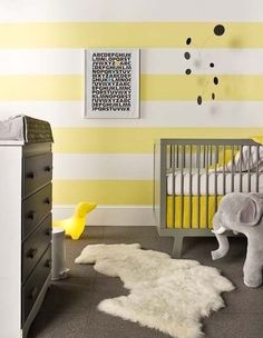 a baby's room with yellow and white striped walls