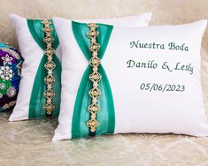 two decorative pillows on a couch with the names of their wedding date and name printed on them