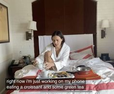 a woman sitting on a bed with food in front of her