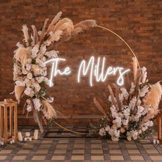 a wedding arch decorated with flowers and pamolite in front of a brick wall