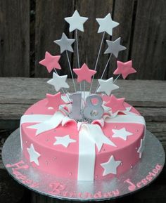 a pink and white birthday cake with stars on it