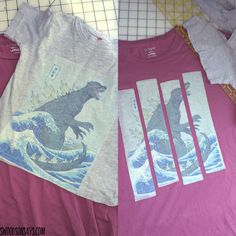 two t - shirts with godzillas on them sitting next to each other in front of a ruler