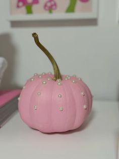 a pink painted pumpkin with pearls on it