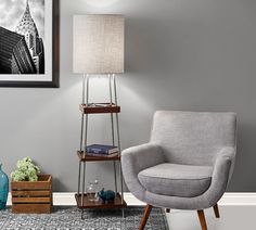 a living room with gray walls and a grey chair next to a lamp on a stand