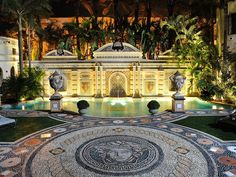 the entrance to an elaborately designed building in black and white with palm trees around it