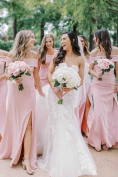 the bride and her bridesmaids are all dressed in pink dresses with white bouquets