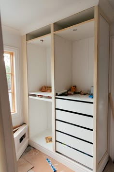 an empty room with white cabinets and drawers