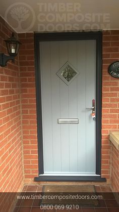 the front door to a brick building with a sign on it that says timber composite doors