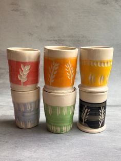 four different colored cups sitting next to each other