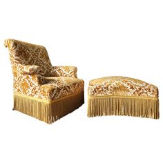 an upholstered chair and ottoman with fringe trim