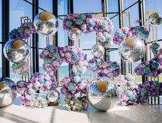 an arrangement of flowers and glass balls in front of a window