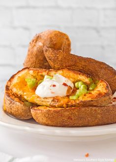 baked potatoes with sour cream and vegetables on a white plate