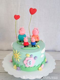 a cake decorated with peppa pig family and hearts