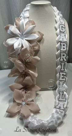 a white headband with flowers on it next to a vase filled with water and bubbles