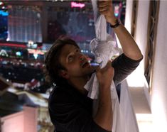 a man holding up a white cloth over his head in front of a cityscape