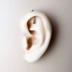 a white ear with a green stone in it