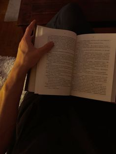 a person is reading a book on the bed