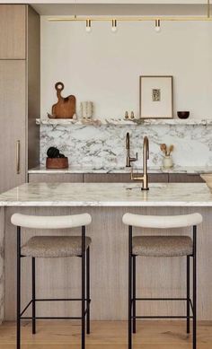 a kitchen with marble counter tops and bar stools