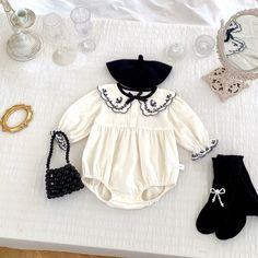 Introducing the Harper Embroidered Romper - perfect for your little one's fall/winter wardrobe. Made with soft cotton and featuring delicate embroidered details on the collar and sleeves, this romper is both stylish and comfortable. The bow appliqué adds a charming touch, while the front buttons and diaper snaps make for easy dressing and changes.