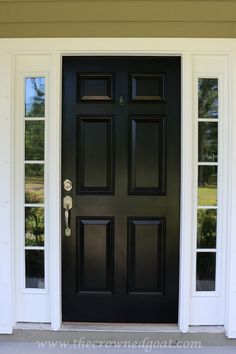 a black front door with white trim and two sidelights on the outside of it