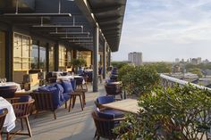 an outdoor restaurant with tables and chairs overlooking the city