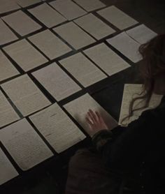 a woman sitting on the floor with papers in front of her