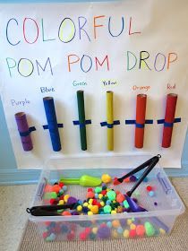 an image of colorful pom poms in a plastic container on the floor next to a bulletin board