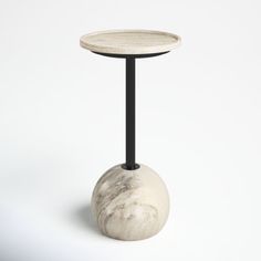 a white marble table with a black metal base and round plate on it's stand