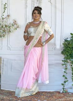 Since time immemorial, pink saree has been a perfect garment that has always reflected a woman’s beauty and elegance! This figure flattering Chiffon saree can be worn as a trendy saree. Fabric & Work Style -- Chiffon saree- Ivory Blouse has beautiful Embossed Print. Size 34-38 Details -- Assured quality.- Wash care instruction: Dry clean only.- Slight variation in color is possible due to digital photography. Pre-draped Saree With Mirror Work In Traditional Drape, Georgette Pre-draped Saree With Mirror Work For Puja, Traditional Drape Saree With Mirror Work, Pink Pre-draped Saree With Unstitched Blouse For Festivals, Designer Pink Pre-draped Saree For Navratri, Bollywood Pre-draped Saree For Puja With Sheer Dupatta, Pink Pre-draped Saree With Mirror Work, Semi-stitched Pre-draped Saree In Georgette, Georgette Pre-draped Saree For Diwali