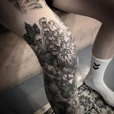 a woman's leg with flowers and butterflies on it