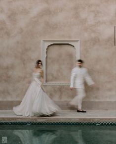 a man and woman in white are standing near a mirror