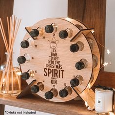 a wooden clock sitting on top of a mantle filled with candles and bottles next to a candle holder