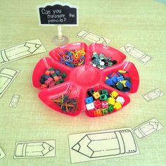 a red tray filled with lots of different colored beads and magnets on top of a table