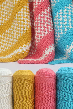 several skeins of yarn are lined up on a white surface with different colors