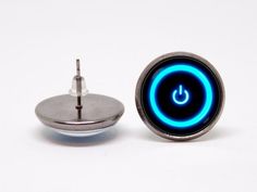 a blue light up button sitting on top of a white table