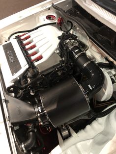 the engine compartment of a sports car with its hood up and it's hood down