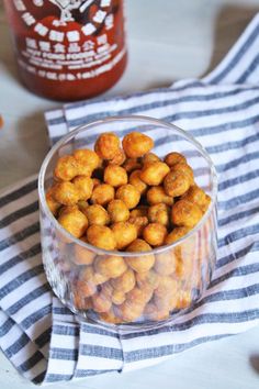 a glass bowl filled with chickpeas sitting on top of a blue and white towel