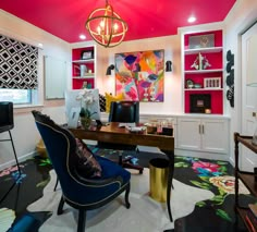 a home office decorated in bright colors with colorful accessories and artwork on the wall behind it