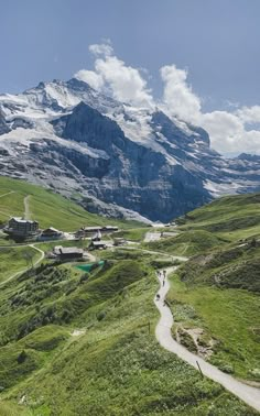 a scenic view of the mountains with people walking up and down one path in the foreground