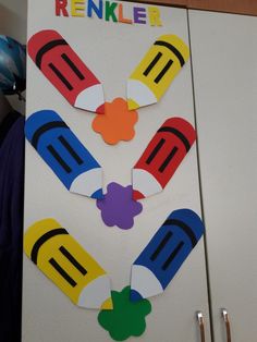 a refrigerator door decorated with magnets and paper cut out to look like crayons