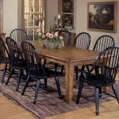 a dining room table with chairs and a rug on the floor