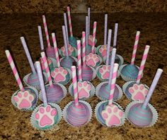 there are many pink and blue cupcakes with paw prints on them