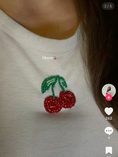 a close up of a person wearing a white shirt with red cherries on it