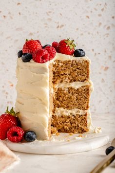 a piece of cake with white frosting and berries on top