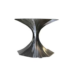 a metal table with an unusual design on the top and bottom, against a white background