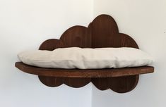 a wooden shelf with a pillow on top of it in the shape of a cloud