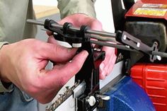 a man is working on a machine with two wrenches and an electric driller